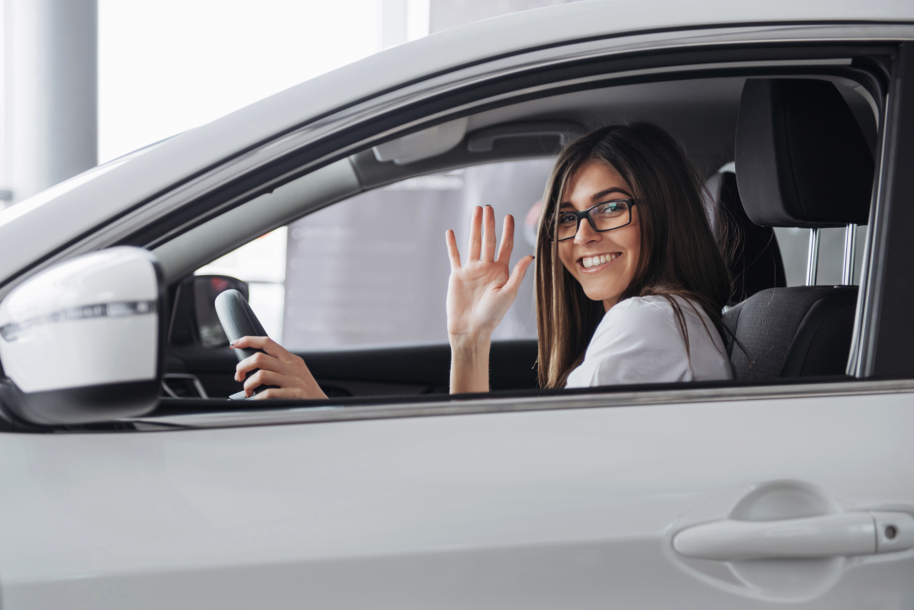 Pretty young woman driving new car. Mujer-con -licencia-de-conducir-guadalajara